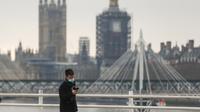 Seorang pria menyusuri Jembatan Waterloo dengan latar Gedung Parlemen di London, Inggris, 29 Desember 2020. Sebanyak 41.385 kasus tambahan COVID-19 dilaporkan di Inggris sehingga menjadi lonjakan tertinggi kasus harian COVID-19 sejak pandemi merebak di negara itu. (Xinhua/Han Yan)