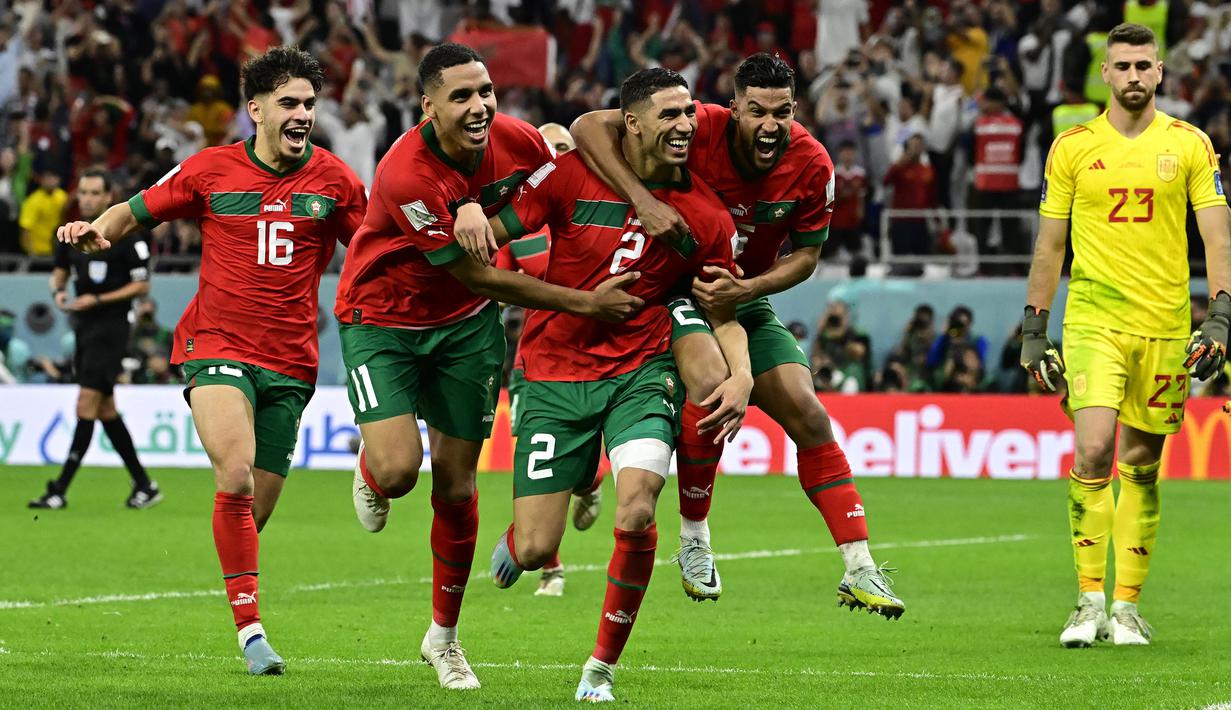 Maroko berhasil mencetak sejarah baru dengan finis di peringkat keempat Piala Dunia 2022. Skuad berjuluk Singa Atlas tersebut secara mengejutkan mampu menaklukkan negara-negara unggulan Eropa seperti Belgia, Spanyol, dan Portugal. Atas penampilan gemilang anak asuh Walid Regragui, Maroko berhasil menjadi tim dengan kenaikan peringkat FIFA paling tinggi. Hakimi dan kolega yang awalnya menduduki peringkat ke-22 naik sebelas tingkat menjadi peringkat ke-11. (AFP/Javier Soriano)