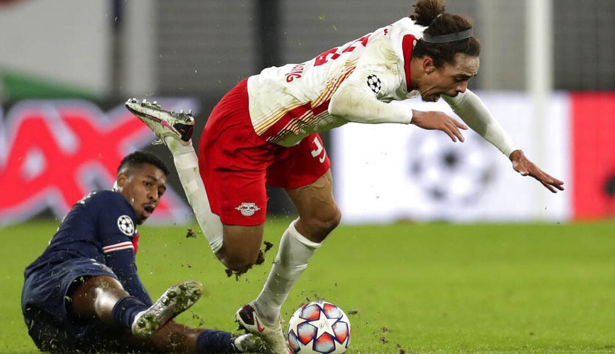 Pemain RB Leipzig, Yussuf Poulsen, terjatuh saat berebut bola dengan pemain Paris Saint Germain, Presnel Kimpembe, pada laga Liga Champions di RB Arena, Kamis (5/11/2020). RB Leipzig menang dengan skor 2-1. (AP/Michael Sohn)