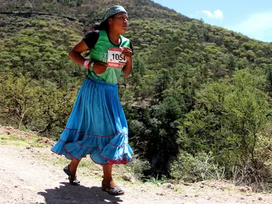 Wanita suku Raramuri dari ras Tarahumara mengikuti lomba lari maraton Ultra Trail Cerro Rojo di negara bagian Chihuahua, Meksiko, Sabtu (15/7). Dalam lomba marathon itu, suku Tarahumara hanya memakai sandal dari karet daur ulang. (Herika MARTINEZ/AFP)