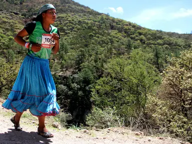 Wanita suku Raramuri dari ras Tarahumara mengikuti lomba lari maraton Ultra Trail Cerro Rojo di negara bagian Chihuahua, Meksiko, Sabtu (15/7). Dalam lomba marathon itu, suku Tarahumara hanya memakai sandal dari karet daur ulang. (Herika MARTINEZ/AFP)