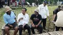 Momen saat Presiden Joko Widodo berdialog dengan warga di Desa Kukuh, Kecamatan Marga, Tabanan, Bali, Jumat (23/2). Para warga tersebut terlibat dalam pelaksanaan padat karya tunai irigasi kecil dan jalan produksi. (Liputan6.com/Pool/Biro Pers Setpres)