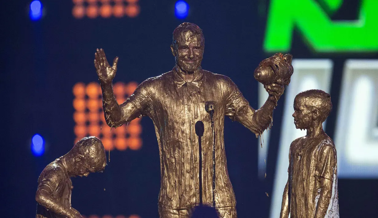 David Beckham serta dua anaknya, Cruz dan Romeo diguyur cairan berwarna emas di atas panggung Nickelodeon, Los Angeles, Kamis (17/7/14). (REUTERS/Mario Anzuoni)