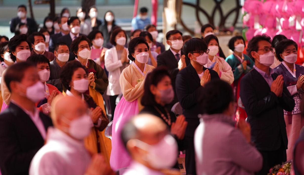 Umat Buddha memakai masker dan menjaga jarak sosial untuk mencegah penyebaran COVID-19 saat upacara merayakan ulang tahun Buddha di Kuil Jogye, Seoul, Korea Selatan, Rabu (19/5/2021). Umat Buddha mengunjungi kuil di seluruh negeri untuk merayakannya ulang tahun Sang Buddha. (AP Photo/Lee Jin-man)