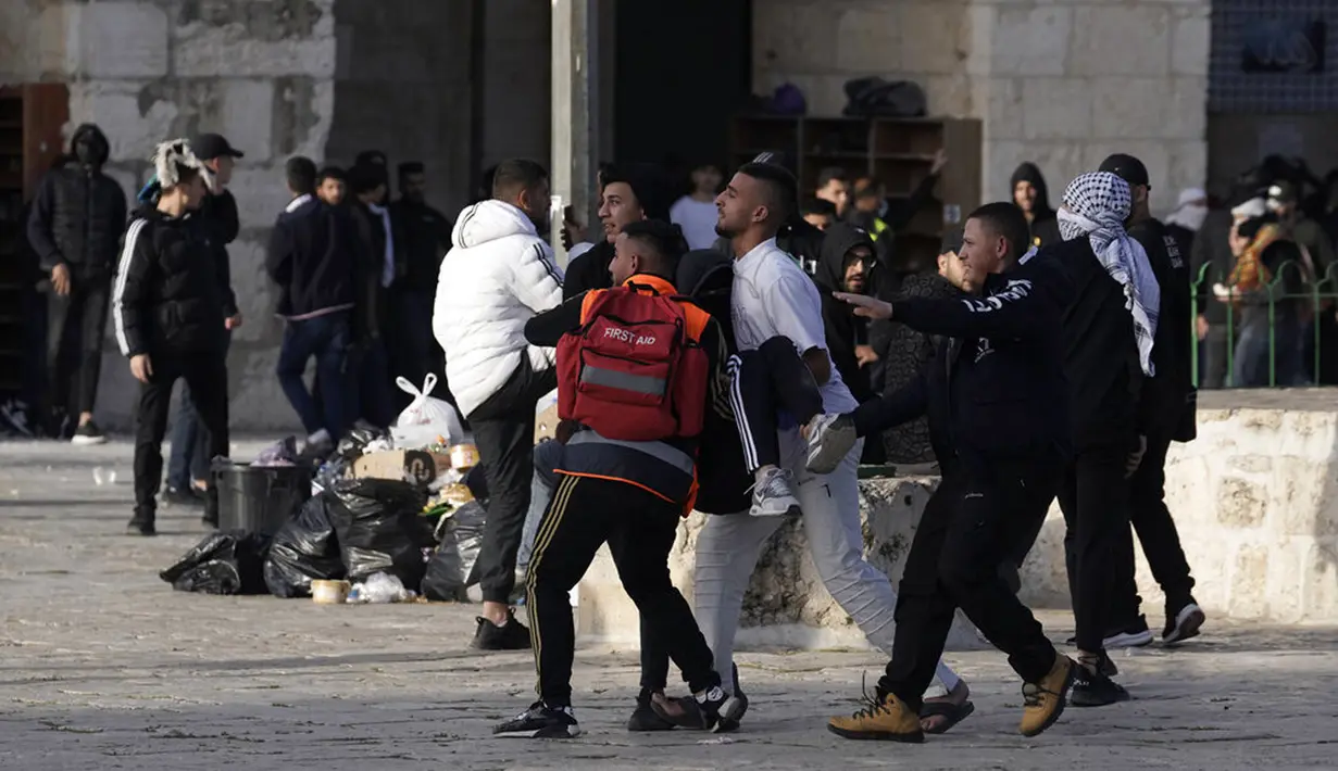 <p>Pengunjuk rasa Palestina yang terluka dalam bentrok dengan polisi Israel dibawa ke tempat aman di Kompleks Masjid Al Aqsa, Yerusalem, Jumat (22/4/2022). Polisi Israel dan pemuda Palestina kembali terlibat bentrok. (AP Photo/Mahmoud Illean)</p>