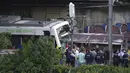 Polisi dan petugas penyelamat berdiri di dekat reruntuhan setelah kecelakaan kereta api di Sant Boi dekat Barcelona, Spanyol, Senin, 16 Mei 2022. Kereta barang menabrak bagian depan kereta penumpang yang sedang keluar dari stasiun. (AP Photo/Joan Mateu Para)
