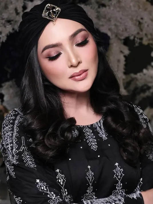 Eyeliner hitam pekat diaplikasikan dengan presisi, menciptakan bentuk mata yang lebih tajam dan terangkat. Sentuhan akhir berupa bulu mata tebal dan lentik semakin menambah kesan dramatis dan glamor. [@ashanty_ash]