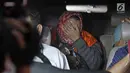 Panitera Pengganti PN Tangerang, Tuti Atika menutup wajah usai diperiksa di gedung KPK, Jakarta, Selasa (13/3). Tuti Atika berstatus tersangka bersama Hakim PN Tangerang Wahyu Widya Nurfitri dan dua pengacara. (Liputan6.com/Herman Zakharia)