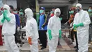 Relawan PMI bersiaga dengan mengenakan jas hujan putih, sarung tangan, dan masker, Pangkalan Bun, Kalteng, Senin (5/1/2015). (Liputan6.com/Herman Zakharia)