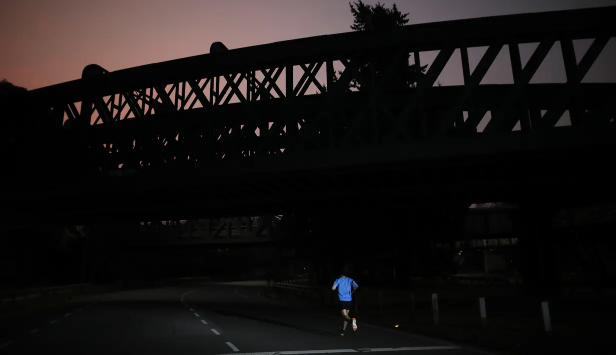 Seorang pria berjogging saat pembukaan kembali area Buenos Aires di Argentina, Senin (20/7/2020). Pembukaan kembali area Buenos Aires, tempat 90% kasus covid-19 ditemukan di Argentina, terjadi saat negara itu melaporkan lebih dari 3 ribu kasus per hari. (AP Photo/Natacha Pisarenko)