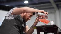 Bartender Mariano Gil menyajikan minuman saat berkompetisi dalam Shake It Up Flair Competition pada hari kedua dari Nightclub & Bar Convention and Trade Show tahunan ke-34 di Las Vegas, Nevada (26/3). (AFP Photo/Ethan Miller)