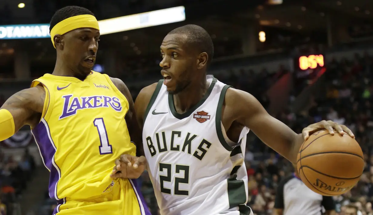 Pebasket Milwaukee Bucks, Khris Middleton, berusaha melewati pebasket LA Lakers, Kentavious Caldwell-Pope, pada laga NBA di Bradley Center, Minggu (12/11/2017). Bucks menang 98-90 atas LA Lakers. (AP/Darren Hauck)