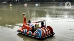 Warga berkeliling dengan menggunakan perahu wisata di Setu Babakan, Jagakarsa, Jakarta Selatan, Minggu (4/4/2021). Setu Babakan kembali dibuka untuk umum pada 27 Maret 2021 dengan menerapkan protokol kesehatan. (merdeka.com/Arie Basuki)