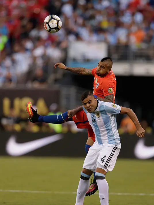 Gelandang Chile, Arturo Vidal berebut bola udara dengan bek Argentina, Gabriel Mercado pada Final Copa America 2016 di MetLife Stadium, AS, Senin (27/6). Chile menang atas Argentina lewat adu penalti dengan skor 4-2. (Adam Hunger-USA TODAY Sports)