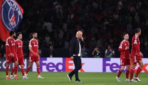 Manajer Liverpool Arne Slot dan para pemain The Reds berjalan lesu usai kalah dari PSG di ajang Liga Champions. (FRANCK FIFE / AFP)