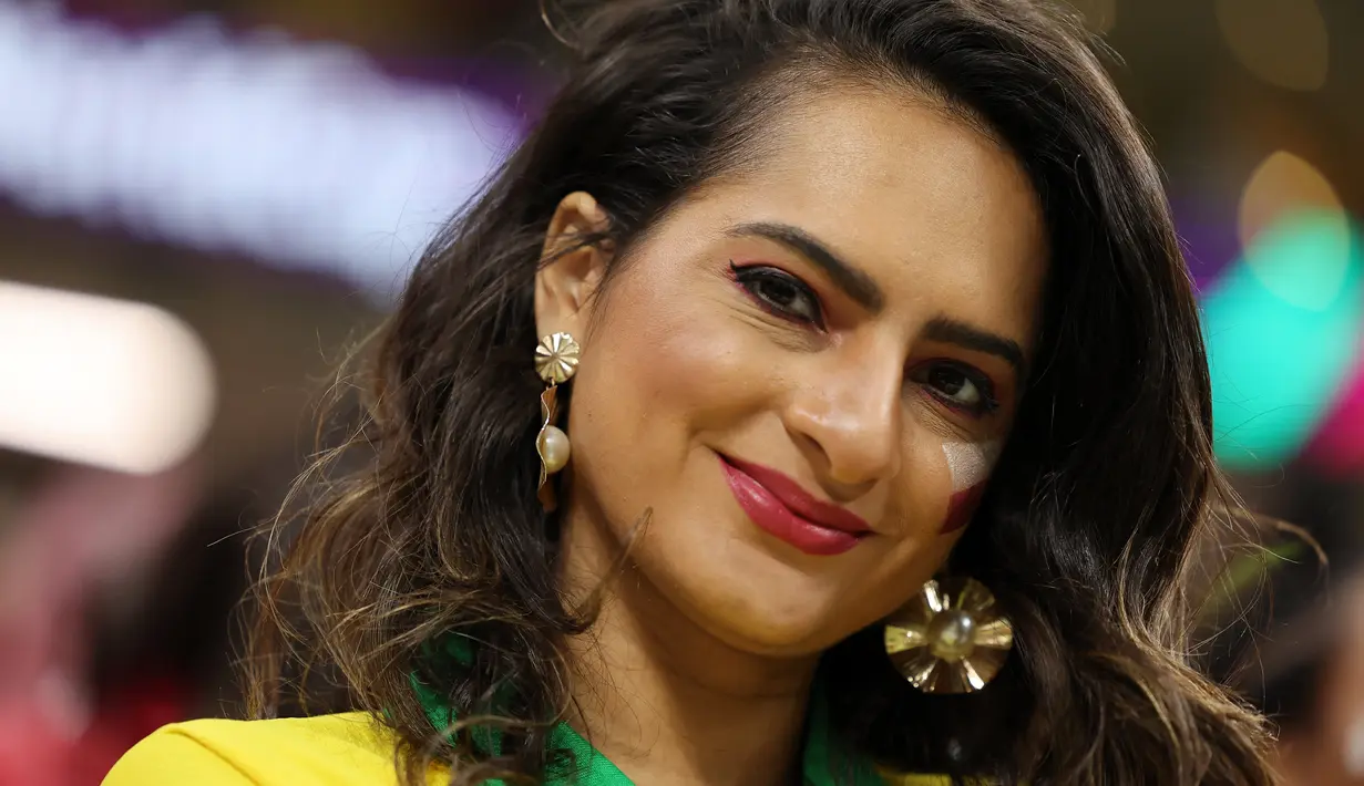 Seorang wanita pendukung Ekuador tersenyum menjelang pertandingan Grup A Piala Dunia Qatar 2022 antara Qatar dan Ekuador di Stadion Al-Bayt di Al Khor, utara Doha pada 20 November 2022. (AFP/Karim Jaafar)