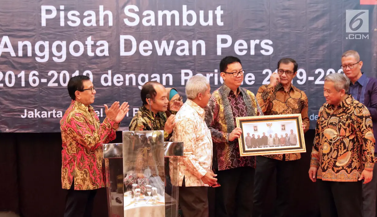 Ketua Dewan Pers periode 2016-2019, Yosep Stanley Adi Prasetyo (tengah) menerima cenderamata dari Ketua Dewan Pers periode 2019-2022, Mohammad Nuh (kanan) saat acara Pisah Sambut Anggota Dewan Pers di Jakarta, Rabu (12/6/2019). (Liputan6.com/Helmi Fithriansyah)