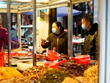 Warga membeli makanan di sebuah kedai di wilayah Xiushan, Chongqing, China barat daya, Jumat (27/2/2020). Kegiatan produksi dan kehidupan sehari-hari warga berangsur normal berkat upaya pengendalian virus corona COVID-19 yang efektif di Xiushan. (Xinhua/Liu Chan)
