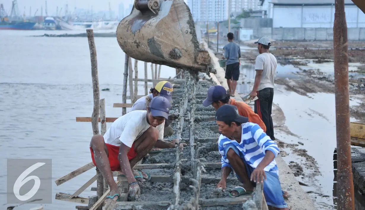 Sejumlah pekerja menyelesaikan proyek pembangunan tanggul di Pantai Muara Baru, Jakarta, Rabu (2/12). Pembangun proyek ini dilakukan di garis bibir pantai sepanjang 32 kilometer. (Liputan6.com/Gempur M Surya)