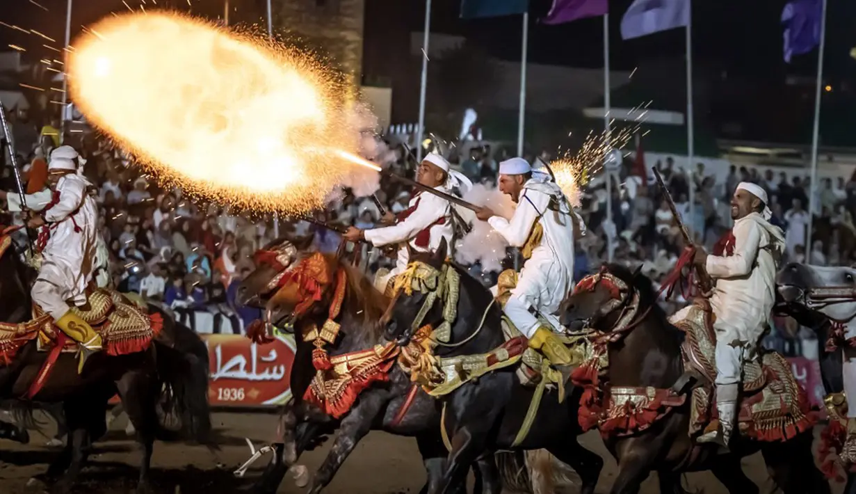 <p>Penunggang kuda Maroko menembakkan senapan mereka selama pertunjukan untuk merayakan festival tahunan Moussem di El Jadida pada 6 Agustus 2023. (Fadel SENNA/AFP)</p>