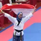 Atlet Taekwondo putri Indonesia, Defia Rosmaniar mengibarkan bendera Merah Putih saat merayakan kemenangan atas Salahshouri Marjan (Iran) pada Final Women Individual Poomsae di JCC, Jakarta, Minggu (19/8). (Liputan6.com/Helmi Fithriansyah)