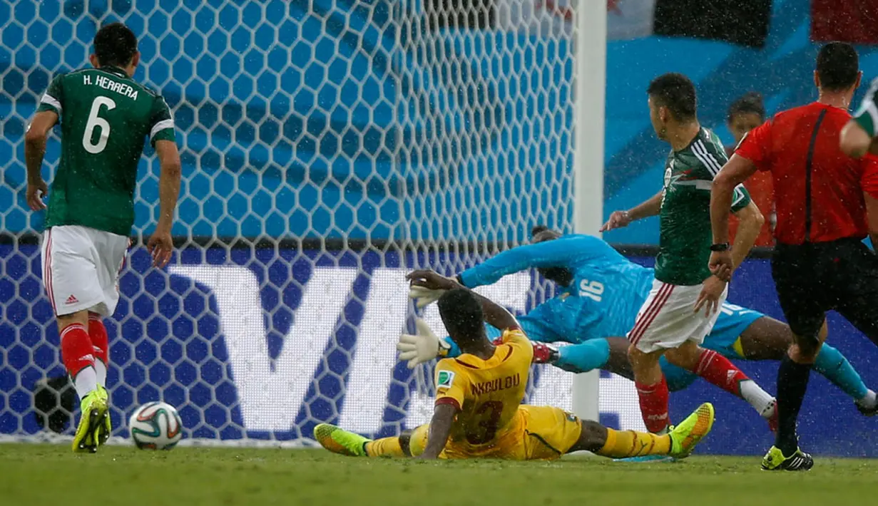 Memanfaatkan bola muntah, penyerang Meksiko, Oribe Peralta (kedua dari kanan) berhasil menjebol gawang Kamerun di babak penyisihan grup A Piala Dunia 2014 di Estadio das Dunas, Natal, Brasil, (13/6/2014). (REUTERS/Toru Hanai)