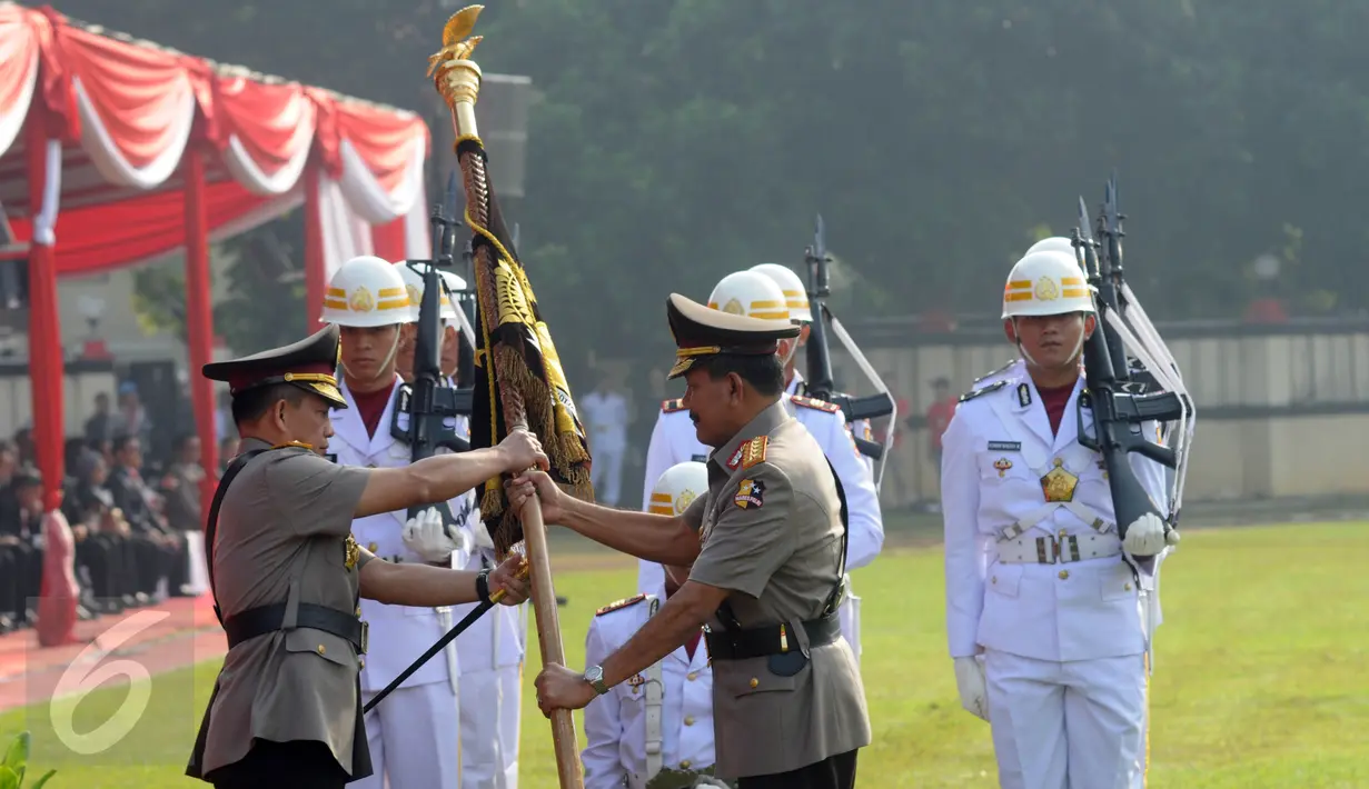 Jenderal Badrodin Haiti menyerahkan panji kepada Jenderal Tito Karnavian dalam upacara sertijab Kapolri di Stadion PTIK, Jakarta, Kamis (14/7). Badrodin Haiti resmi menyerahkan tongkat komando Kapolri kepada Tito Karnavian. (Liputan6.com/Helmi Afandi)
