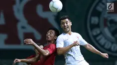 Gelandang Timnas Indonesia, Bayu Pradana (kiri) berebut bola dengan pemain Hong Kong, Giovane Alves Da Silva pada laga uji coba internasional di Stadion Wibawa Mukti, Cikarang, Selasa (16/10). Laga berakhir imbang 1-1. (Liputan6.com/Helmi Fithriansyah)