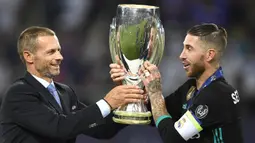 Kapten Real Madrid, Sergio Ramos, menerima trofi Piala Super Eropa usai mengalahkan Manchester United di Stadion Philip II, Skopje, Selasa (8/8/2017). Ini merupakan gelar Piala Super Eropa keempat bagi Real Madrid. (AFP/Dimitar Dilkoff)