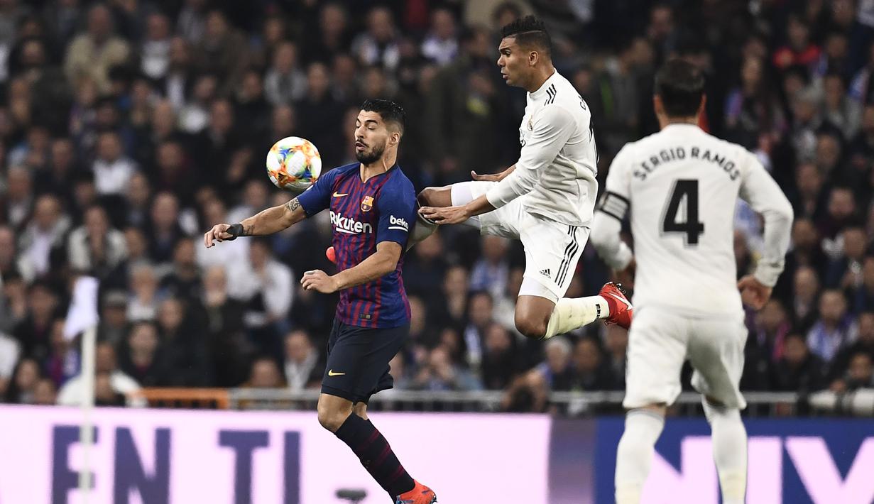 Duel antara Luis Suarez dan Casemiro pada laga semfinal Copa Del Rey yang berlangsung di stadion Santiago Bernabeu, Madrid, Kamis (28/2). Barcelona menang 3-0 atas Real Madrid. (AFP/Oscar Del Pozo)
