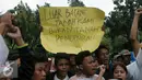 Puluhan pemuda kampung Luar Batang mengangkat tulisan saat melakukan aksi di depan Balai Kota Jakarta, Jumat (22/4/2016). Mereka mempertanyakan kebijakan Pemprov DKI Jakarta yang melakukan penggusuran. (Liputan6.com/Helmi Fithriansyah)