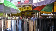 Seorang pedagang menata celana panjang sambil menunggu pelanggan pakaiannya di salah satu ruas jalan, Surabaya, Jawa Timur, pada Minggu 19 April 2026. Badan Pusat Statistik (BPS) Republik Indonesia akan melaksanakan Sensus Ekonomi 2026 (SE2026). (JUNI KRISWANTO/AFP)
