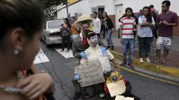  Patung yang dipasang gambar Presiden Venezuela Nicolas Maduro (atas) saat akan dibakar oleh warga di Caracas , Venezuela, (27/3). Hal ini dilakukan dalam perayaan Paskah di Caracas. (REUTERS / Marco Bello)