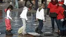 Sejumlah anak mengenakan kantong plastik untuk melindungi kakinya saat melitasi sungai untuk bertemu keluarganya di perbatasan Meksiko-AS di Ciudad Juarez, Meksiko (28/1). (AP Photo/Christian Torres)