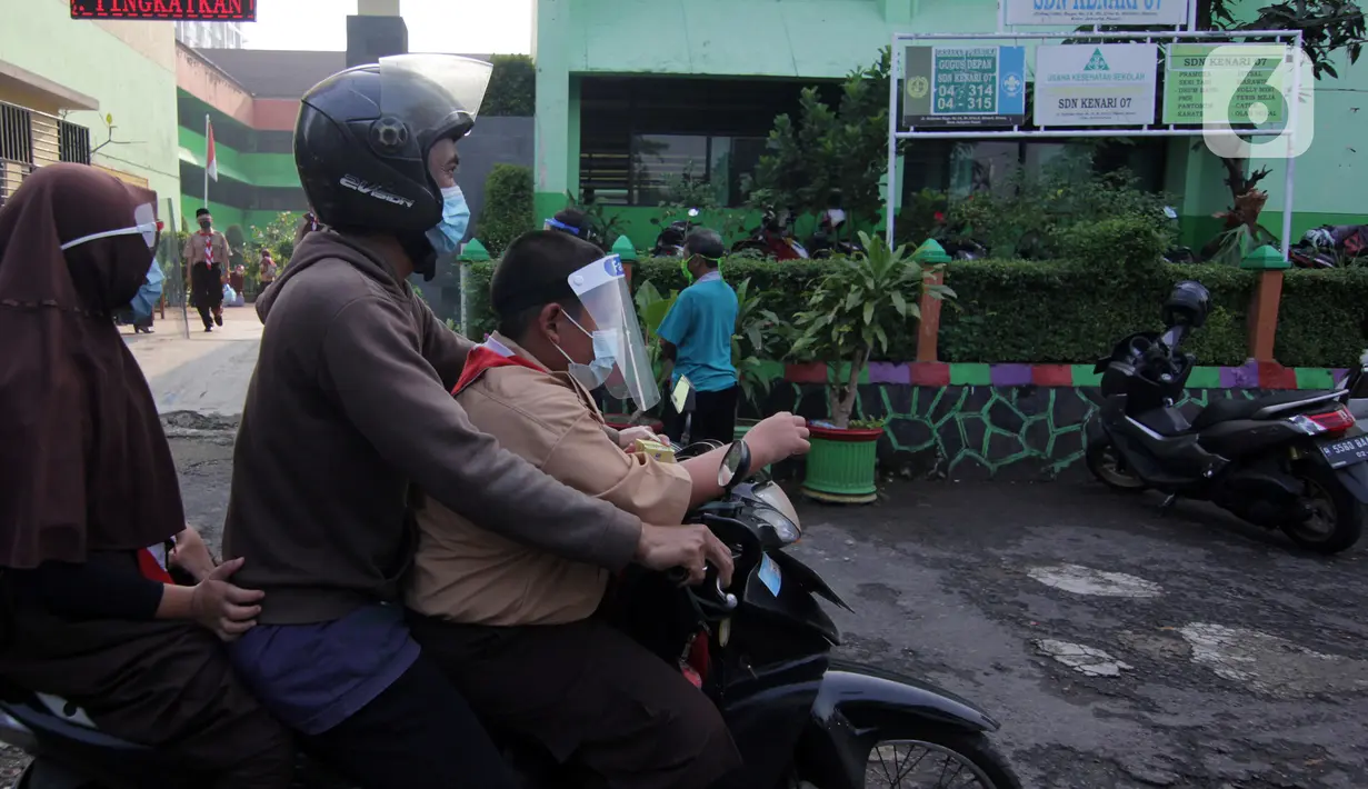 Orangtua siswa menjemput anaknya saat uji coba belajar tatap muka di SDN Kenari 07/08 Pagi, Jakarta, Rabu (9/6/2021). SDN Kenari 07/08 Pagi menjadi salah satu dari 226 sekolah di Jakarta yang ditetapkan sebagai tempat uji coba kegiatan belajar tatap muka tahap kedua. (Liputan6.com/Herman Zakharia)