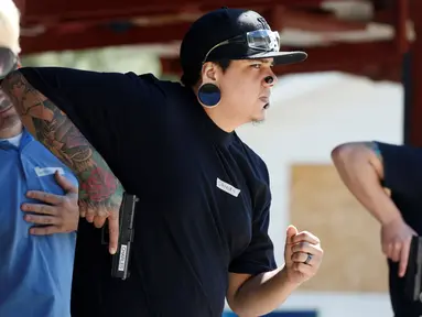 Anggota Pink Pistols bersiap menembak saat mengikuti kelas pelatihan tembak di PMAA Gun Range, Salt Lake City, Utah, AS (13/7). Pink Pistols adalah organisasi pro-senjata nasional LGBT di AS. (REUTERS/Jim Urquhart)