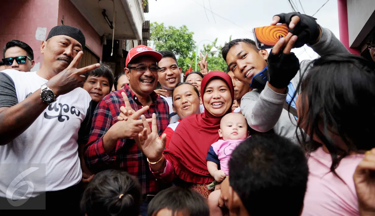 Cagub DKI Jakarta Djarot Saiful Hidayat foto bersama warga Rawa Terate, Jakarta, Kamis (12/1). Warga Terate berharap pasangan tersebut dapat meneruskan program-program yang selama ini telah berjalan untuk memajukan Jakarta. (Liputan6.com/Gempur M Surya)