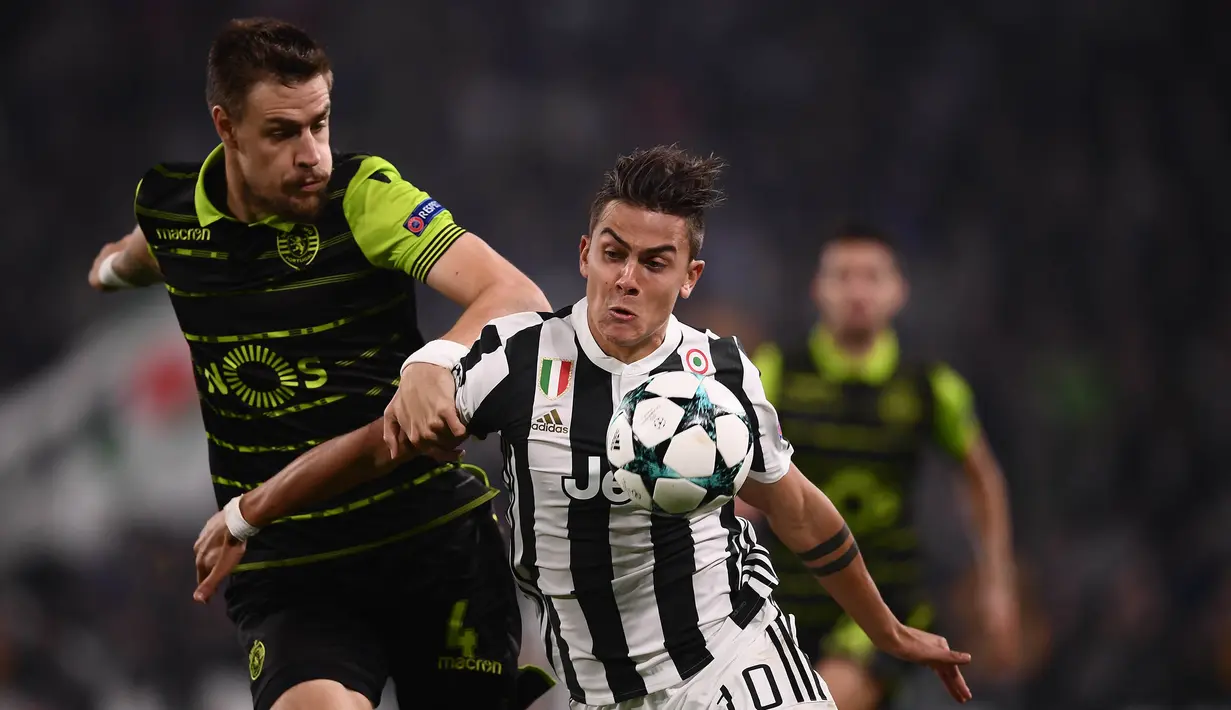 Striker Juventus, Paulo Dybala, berusaha melewati bek Sporting Lisbon, Sebastien Coates, pada laga Liga Champions di Stadion Allianz, Turin, Rabu (18/10/2017). Juventus menang 2-1 atas Sporting. (AFP/Marco Bertorello)