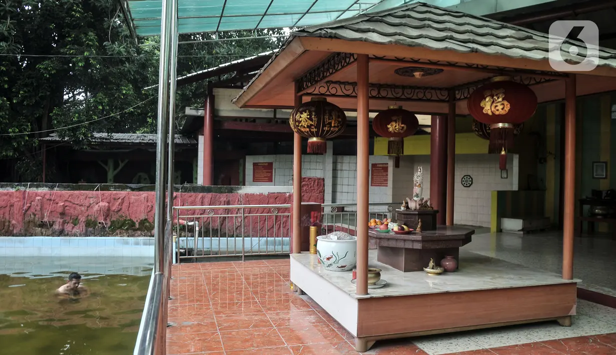 Warga keturunan Tionghoa berenang saat membersihkan diri di salah satu sumur Vihara Gayatri, Depok, Jawa Barat, Minggu (15/1/2023). (merdeka.com/Iqbal S. Nugroho)