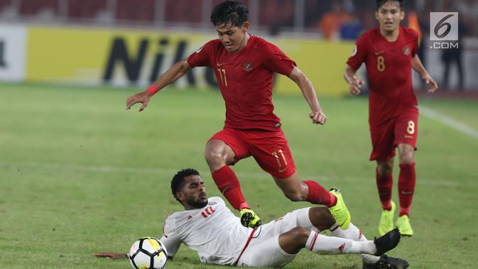 Bek timnas Indonesia -19, Firza Andika melompat menghindari tekel pemain Uni Emirat Arab U-19, Tahnoon Hamdan pada penyisihan Grup A Piala AFC U-19 2018 di Stadion GBK, Jakarta, Rabu (24/10). Indonesia unggul 1-0. (Liputan6.com/Helmi Fithriansyah)