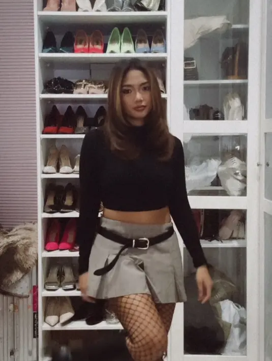 Marion Jola hadir menjadi Rachel Green dalam serial Friends. Ia mengenakan atasan crop lengan panjang hitam dipadukan mini skirt pleated abu-abu dengan belt hitam. Serta stocking jaring dipadukan boots hitam. [@lalamarionmj]