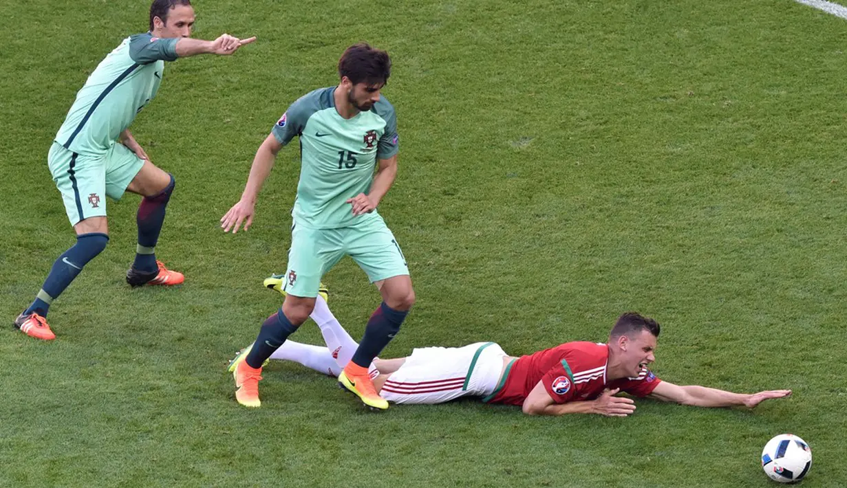 Pemain Portugal berusaha menghentikan pergerakan pemain Hungaria, Adam Szalai, pada laga Grup F Piala Eropa 2016 di Stade de Lyon, Lyon, Rabu (22/6/2016). (AFP/Jean-Philippe Ksiazek)