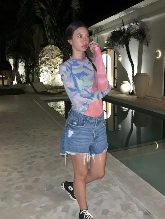 Yuki memadukan atasan lengan panjang bodycon dengan celana short denimnya. Dipadukan converse high hitam. [Instagram/@Yukikt]