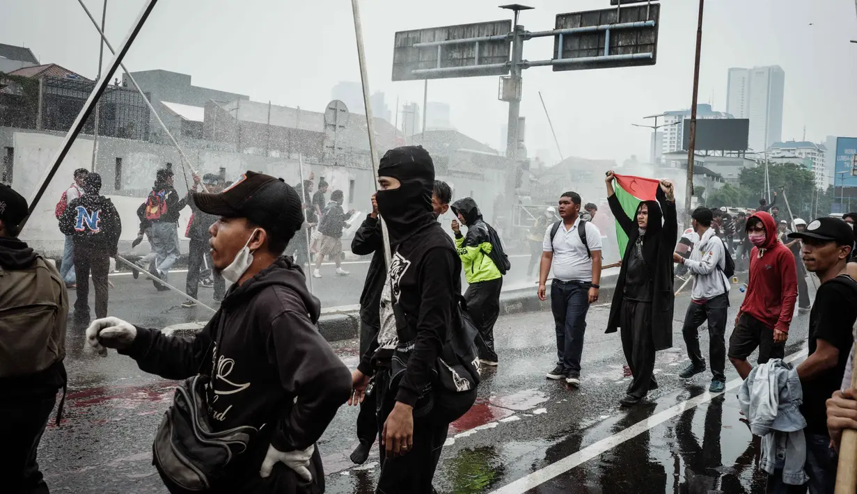 Aparat juga menembakkan water cannon untuk membubarkan aksi unjuk rasa. (YASUYOSHI CHIBA/AFP)