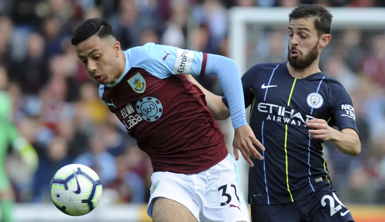 Gelandang Manchester City, Bernardo Silva, berebut bola dengan pemain Burnley, Dwight McNeil, pada laga Premier League di Stadion Turf Moor, Minggu (28/4). Manchester City menang 1-0 atas Burnley. (AP/Rui Vieira)