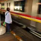 Tampak seorang  wanita yang sedang berdiri  menunggu kereta Commuter Line datang (Liputan6.com/ 
JohanTallo)
