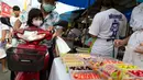 Orang-orang membeli manisan dalam Festival Vegetarian Phuket 2020 di Phuket, Thailand (20/10/2020). Festival ini tetap menjalankan kebijakan jaga jarak sosial (social distancing) ketat di tengah pandemi COVID-19 yang masih berlangsung. (Xinhua/Zhang Keren)