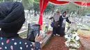 Warga berpose dengan makam Presiden ke-3 RI BJ Habibie dan sang istri, Hasri Ainun Besari di Taman Makam Pahlawan Kalibata, Jakarta, Jumat (13/9/2019). Sehari setelah pemakaman, warga masih berdatangan ke makam Habibie untuk memanjatkan doa dan berfoto. (Liputan6.com/Herman Zakharia)