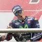 Pembalap Movistar Yamaha, Maverick Vinales merayakan kemenangannya setelah finis pertama pada MotoGP Argentina dengan menyemprotkan sampanye bersama Valentino Rossi di atas podium Sirkuit Termas de Rio Hondo, Minggu (9/4). (AP Photo/Nicolas Aguilera)