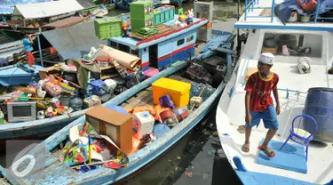 Seorang anak berada di atas kapal saat rumahnya mulai dihancurkan oleh alat berat petugas, Jakarta, Senin (11/4). Pemprov DKI membongkar ratusan rumah di wilayah Pasar Ikan. (Liputan6.com/Yoppy Renato)